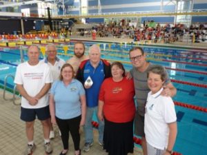 This image shows Molonglo Water Dragons team members poolside. Left to right: Ross Burden, Gary Stutsel, Mary Liz Partridge, Gavin Atherton, John Collis, Tanya Colyer, Ed Auzins and Margaret Larkin